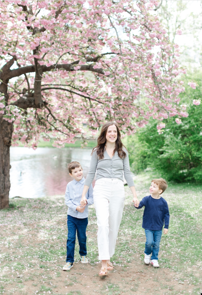 Mom, dad, and two sons in front of cherry blossoms at Taylor Park in Millburn, NJ.
